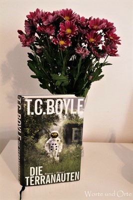 Gebundene Ausgabe des Romans Die Terranauten mit Blumenstrauß